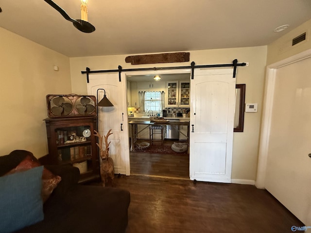 interior space featuring a barn door, wood finished floors, and visible vents