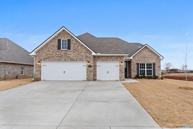 view of front facade featuring brick siding, roof with shingles, concrete driveway, and a front lawn