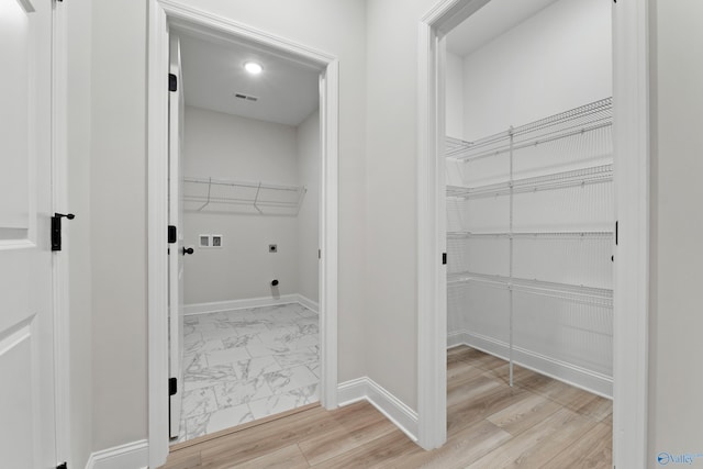 laundry room with electric dryer hookup, marble finish floor, baseboards, hookup for a washing machine, and laundry area