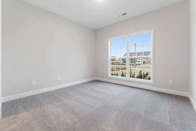 empty room with visible vents, baseboards, and carpet flooring