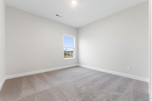 unfurnished room with visible vents, baseboards, and carpet floors