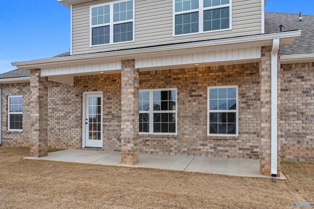 back of property featuring a patio area and a shingled roof