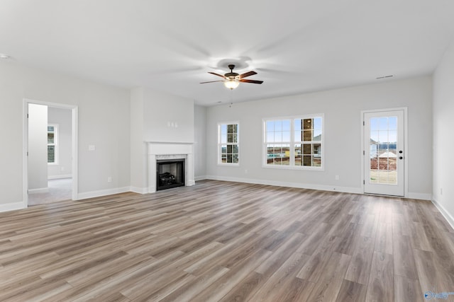 unfurnished living room featuring a fireplace, baseboards, and light wood-style floors