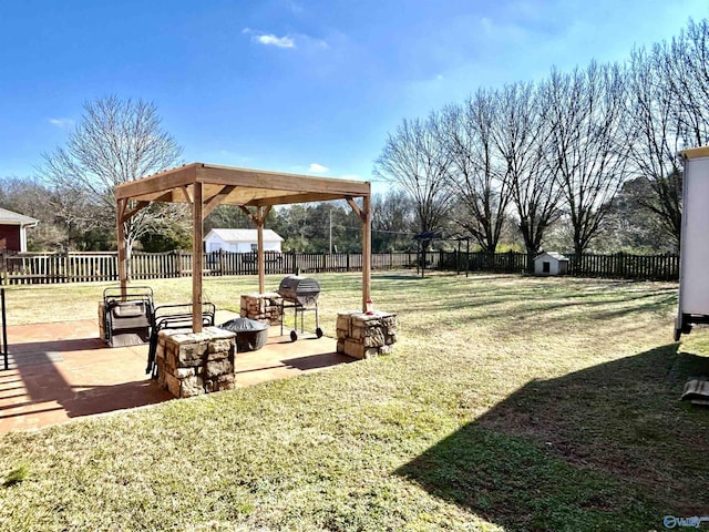 view of yard featuring a storage shed, a patio area, and an outdoor fire pit