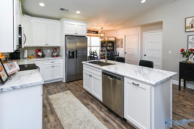 kitchen with pendant lighting, white cabinetry, stainless steel appliances, and an island with sink