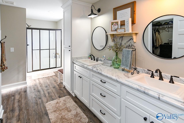 bathroom featuring vanity, hardwood / wood-style floors, and a shower with door