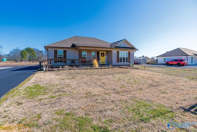 ranch-style house featuring a porch and a front lawn