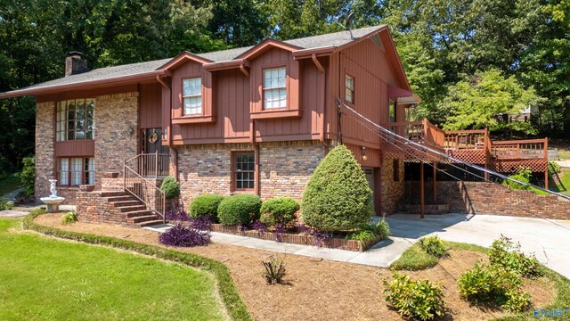 split foyer home featuring a wooden deck and a front lawn