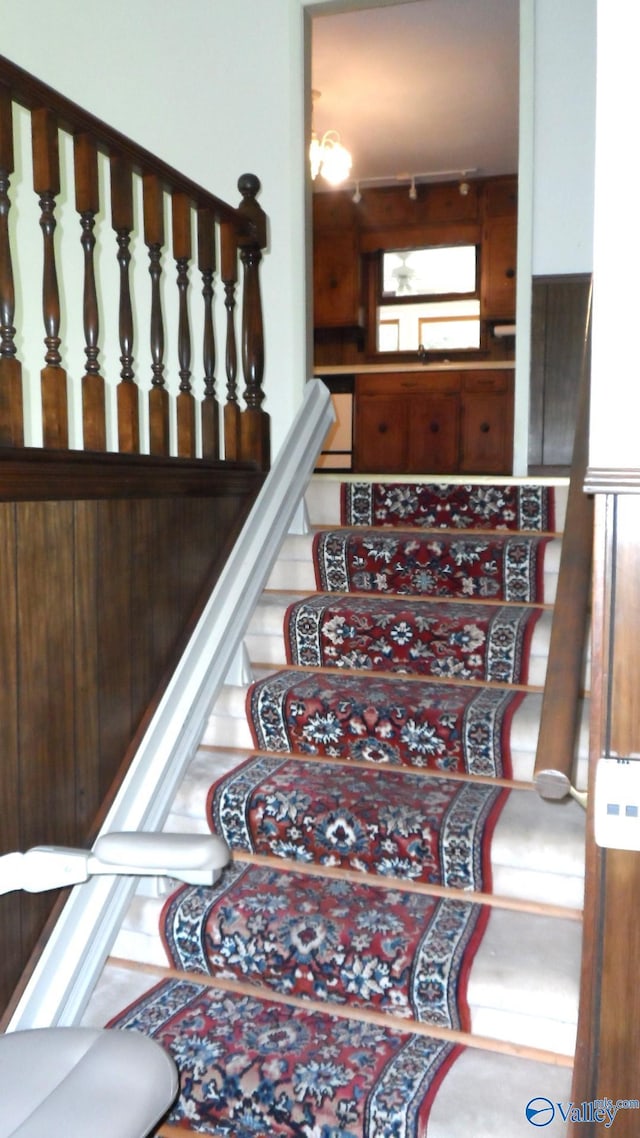 stairs with an inviting chandelier