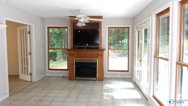 unfurnished living room with ceiling fan, light tile patterned floors, and plenty of natural light