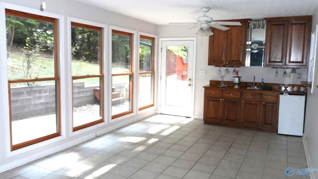 kitchen with white dishwasher, light tile patterned floors, and a healthy amount of sunlight