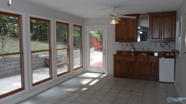 kitchen with ceiling fan, light tile patterned floors, a healthy amount of sunlight, and dishwasher