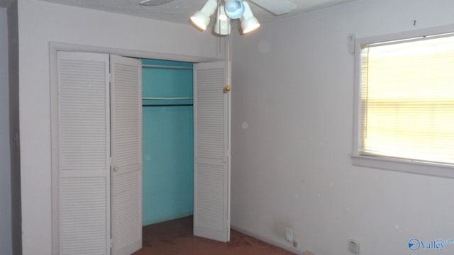 unfurnished bedroom with ceiling fan and a closet