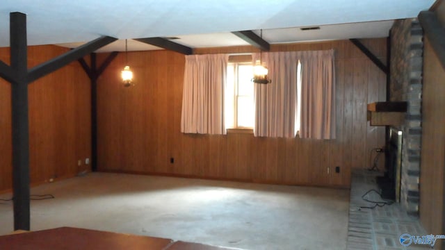 interior space with wood walls, carpet flooring, a fireplace, and beamed ceiling