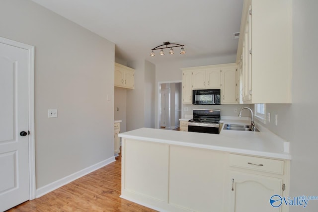 107 Palomino Ct, Madison, AL 35758 - kitchen featuring black microwave, range, a peninsula, light countertops, and light wood finished floors
