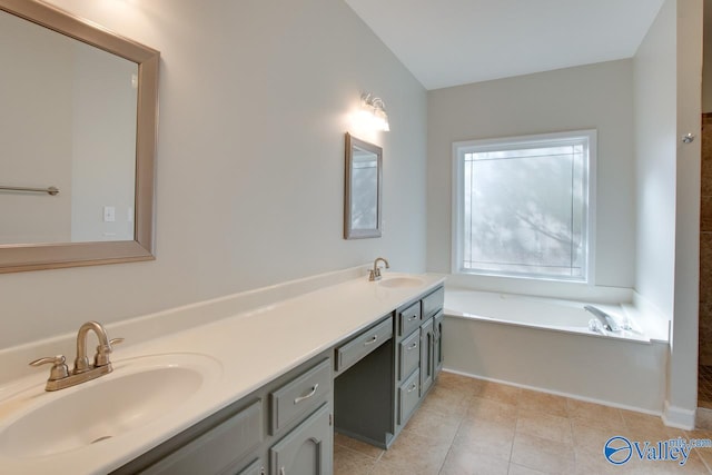 bathroom with a bathing tub, tile patterned flooring, and vanity