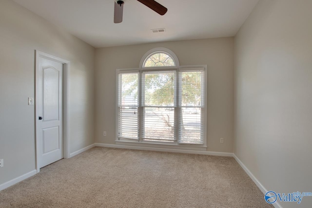 carpeted spare room with ceiling fan