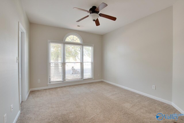 spare room with ceiling fan and light colored carpet