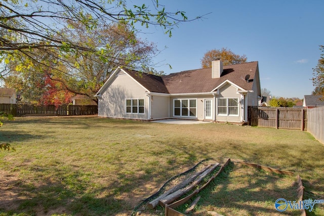 back of house featuring a patio area and a lawn