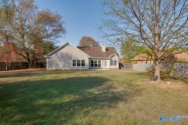 rear view of property with a yard