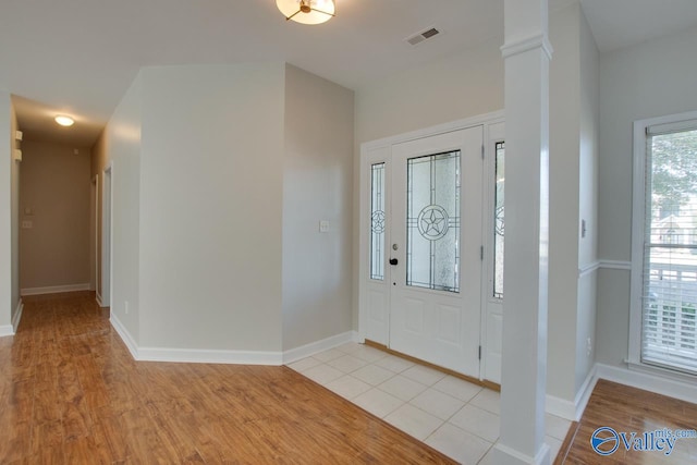 foyer featuring light hardwood / wood-style floors and decorative columns