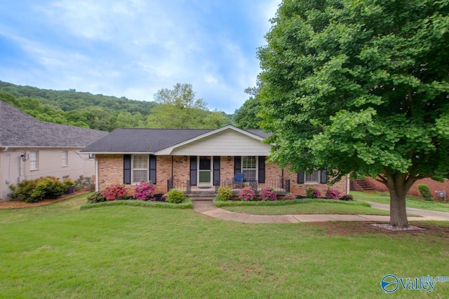 single story home featuring a porch, a front lawn, and brick siding