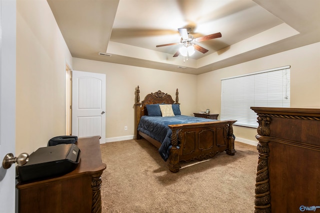 bedroom featuring a tray ceiling, ceiling fan, and light colored carpet