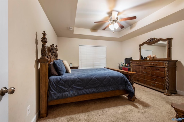 bedroom with ceiling fan, a raised ceiling, and carpet floors