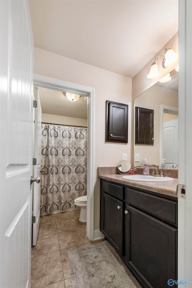 bathroom with curtained shower, vanity, toilet, and tile patterned floors