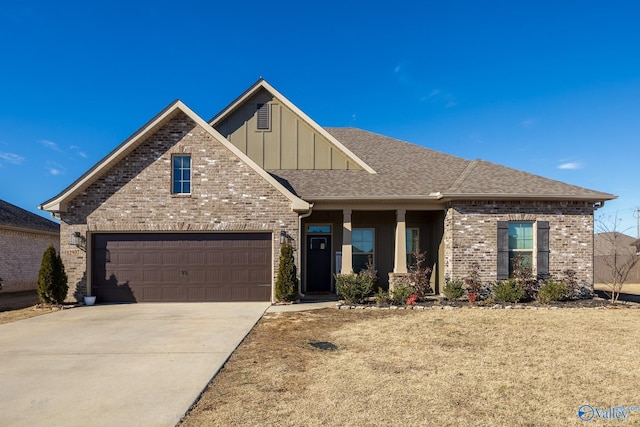 view of front facade featuring driveway, a garage, a shingled roof, board and batten siding, and brick siding