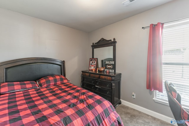 bedroom with visible vents, multiple windows, baseboards, and carpet flooring