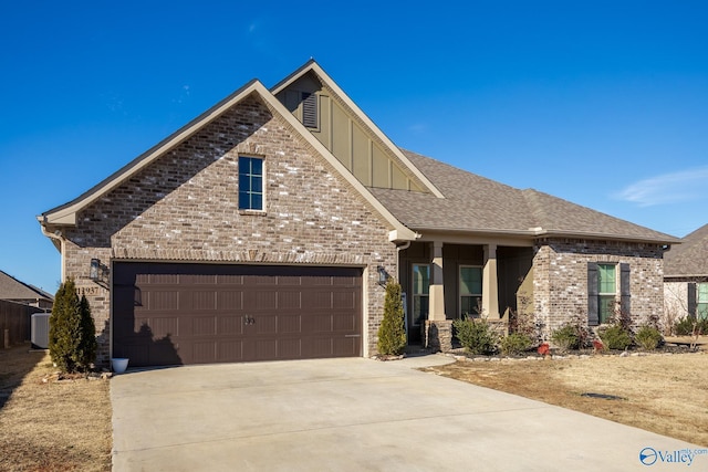 view of front of home featuring board and batten siding, brick siding, driveway, and a garage