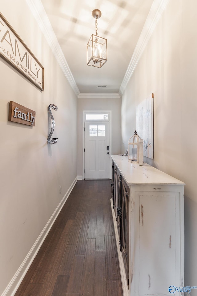 doorway featuring dark hardwood / wood-style floors, crown molding, a chandelier, and washing machine and dryer