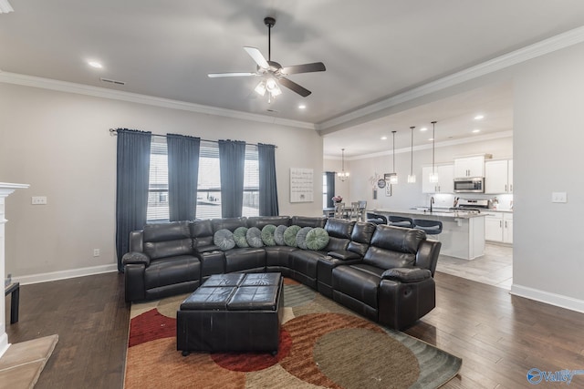 living room featuring ornamental molding, baseboards, and wood finished floors