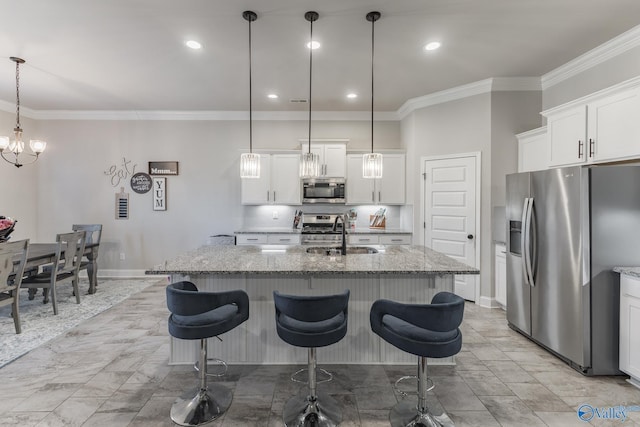 kitchen featuring a breakfast bar area, appliances with stainless steel finishes, light stone counters, ornamental molding, and a sink