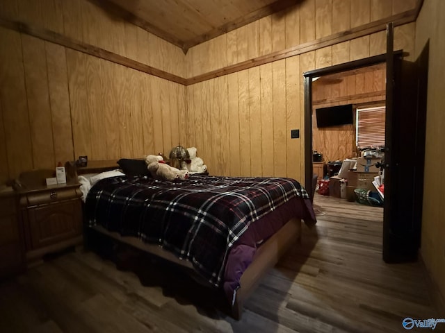 bedroom featuring dark wood-style floors and wooden walls