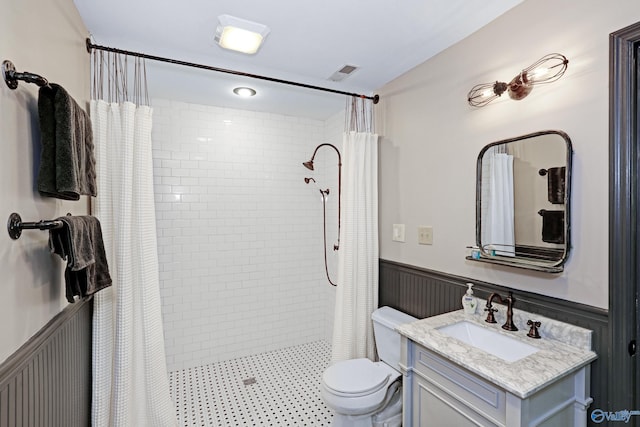 bathroom featuring vanity, walk in shower, and toilet