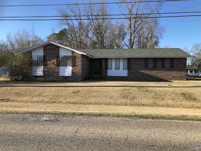 view of front facade featuring crawl space, brick siding, and a front lawn