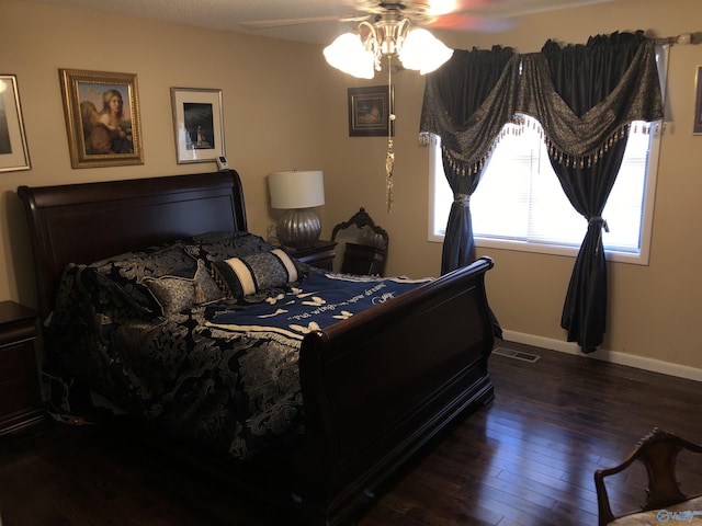 bedroom featuring ceiling fan, visible vents, baseboards, and dark wood-style flooring