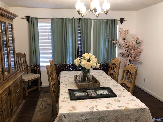 dining room with a textured ceiling, baseboards, dark wood finished floors, and an inviting chandelier