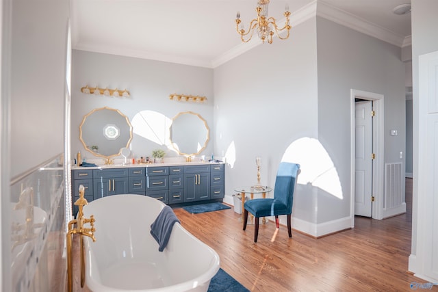 bathroom featuring an inviting chandelier, a washtub, hardwood / wood-style flooring, and crown molding