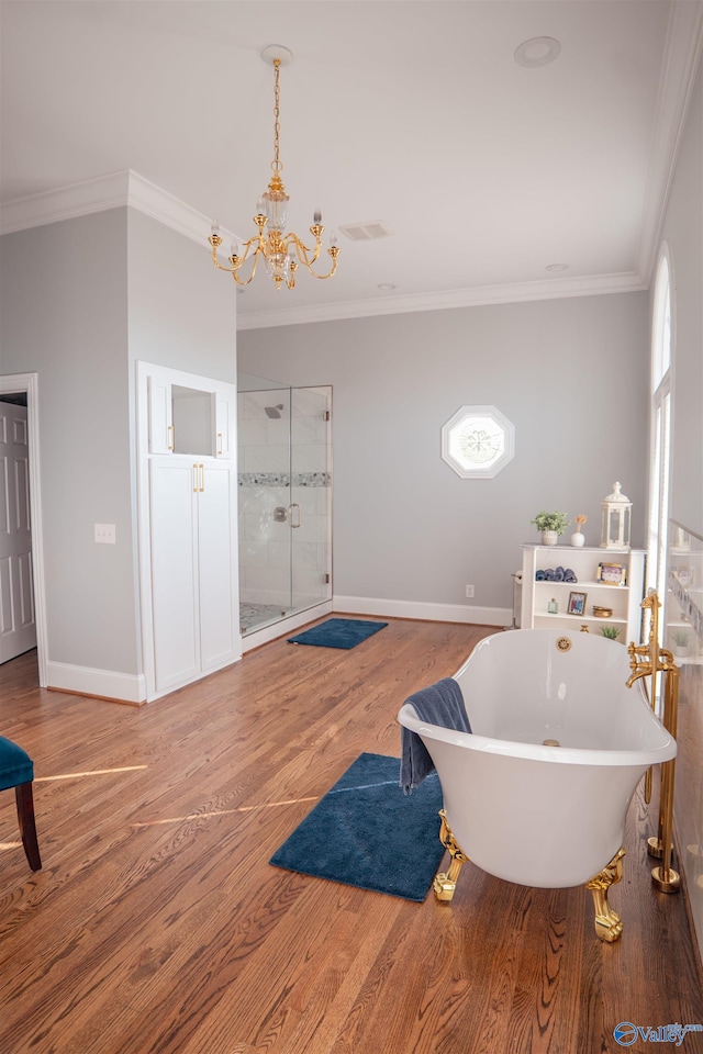 bathroom with plus walk in shower, ornamental molding, and hardwood / wood-style flooring