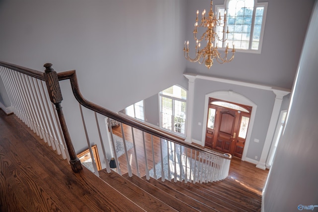 entryway featuring dark wood-type flooring, a notable chandelier, and a healthy amount of sunlight