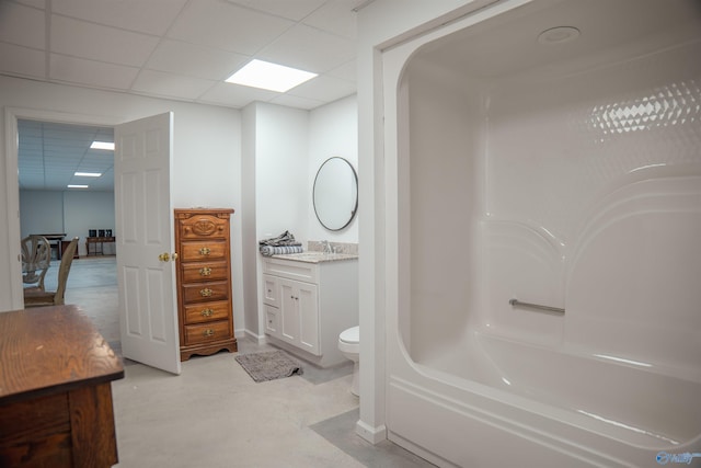 full bathroom with washtub / shower combination, a drop ceiling, toilet, and vanity