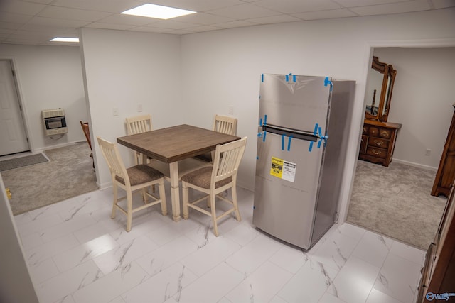 tiled dining area featuring a drop ceiling and heating unit