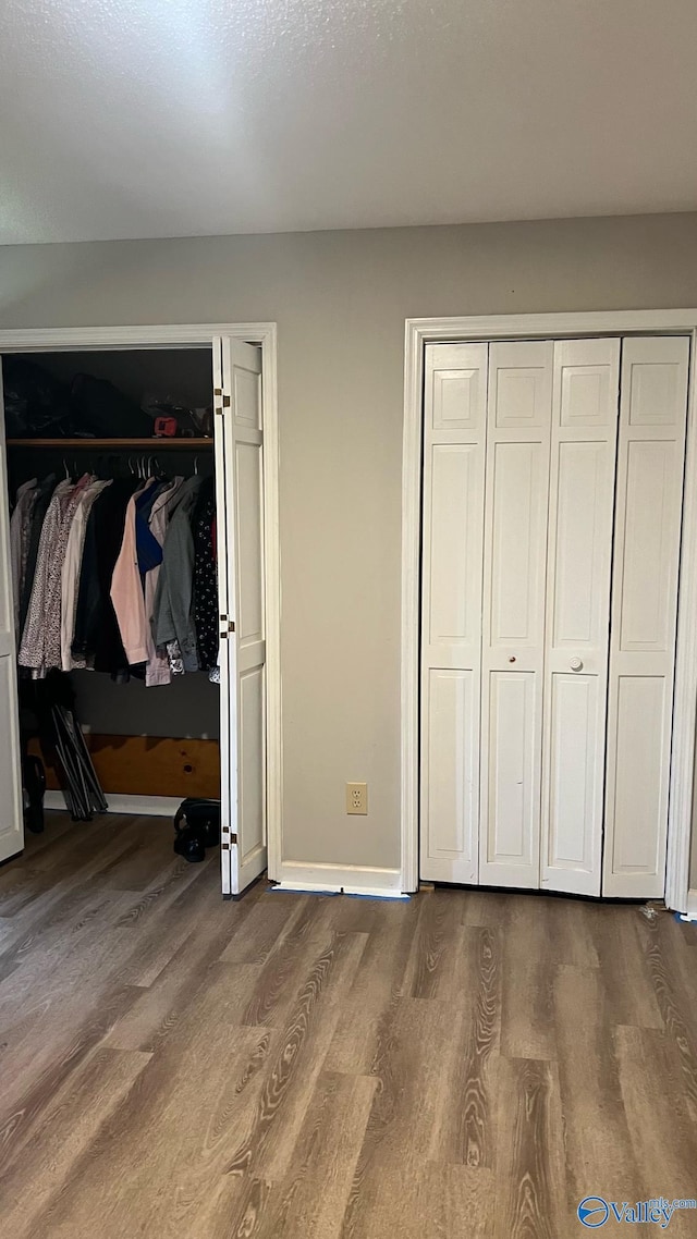 unfurnished bedroom featuring baseboards and dark wood finished floors