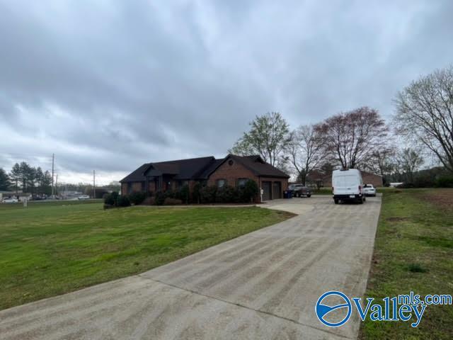 view of front of property with a garage, a front lawn, and concrete driveway