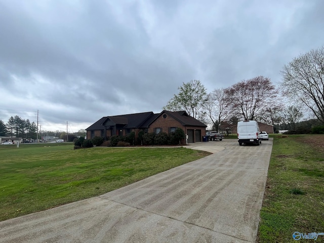 view of front of property featuring concrete driveway, a garage, and a front lawn