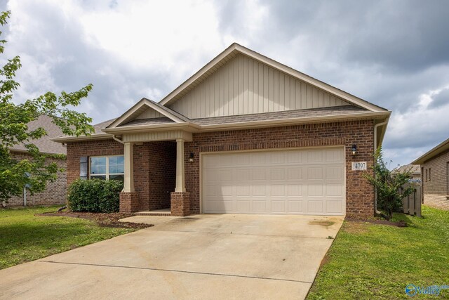 14797 Eva Cir, Athens, AL 35613 - view of front of house featuring brick siding, board and batten siding, a garage, concrete driveway, and a front yard