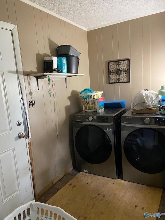 121 County Road 575, Rogersville, AL 35652 - laundry area featuring washing machine and clothes dryer, a textured ceiling, crown molding, and a decorative wall